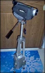 A digital video camera on a cheap tripod with its legs duct-taped around a milk jug, in front of fake wood-paneled kitchen cabinets.  No, seriously.